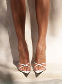 Close-up of a model wearing the Donatella Mule in Patent White, showing the criss-cross strap design across the open toe