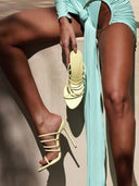 Model wearing the Kalós Slipper in Yellow patent, close-up on foot and ankle